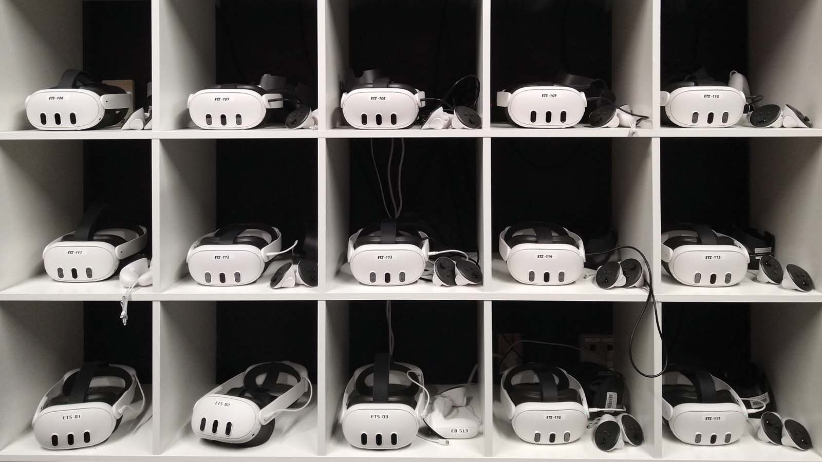 Fifteen VR headsets displayed in a shelf organizer