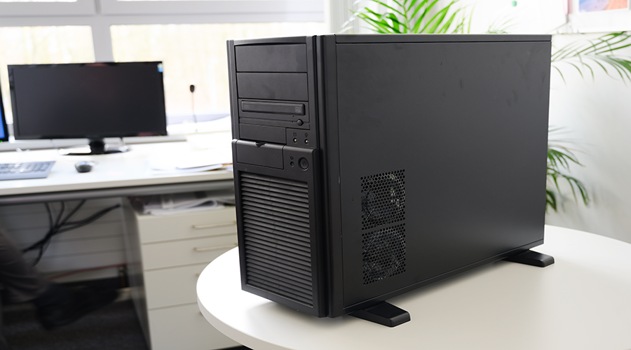 A desktop PC sitting on a table with a monitor behind it.