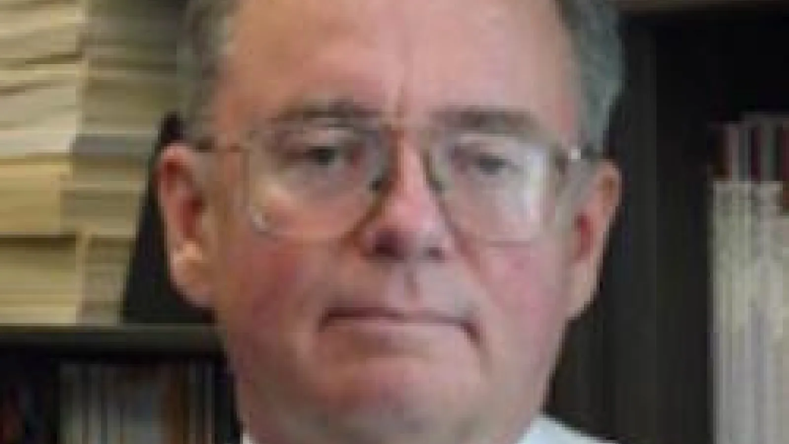 John Heimaster in front of a tall bookcase