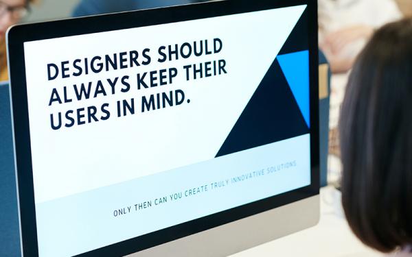 Monitor showing message that designers should keep users in mind