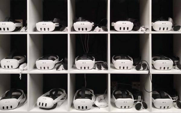 Fifteen VR headsets displayed in a shelf organizer