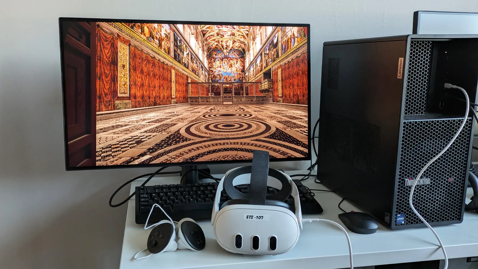 Monitor displaying a virtual simulation of Sistine Chapel, and a VR headset in front of it