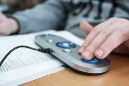 A visually impaired man uses a scanning and reading machine.